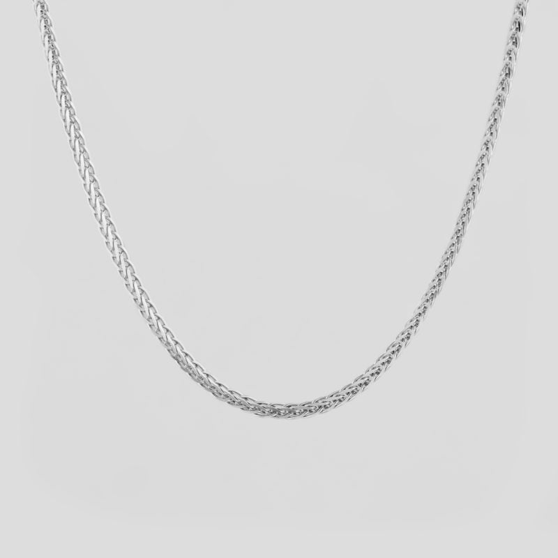 Silver chain necklace on a light gray background
