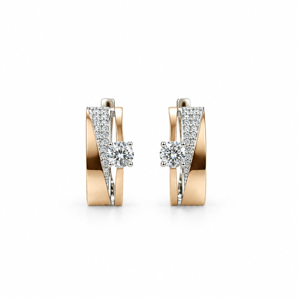     Pair of curved silver earrings with 375 gold accents and clear stones on a white background