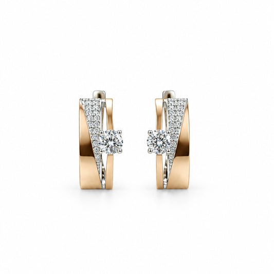     Pair of curved silver earrings with 375 gold accents and clear stones on a white background